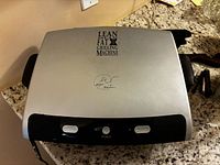 Closed grill showing brand logo on lid