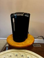 Front and left side view of black Keurig single-serve coffee maker on table