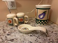 Utensil holder, salt & pepper shakers, spoon rest grouped on countertop