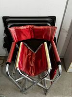 Red folding chair in front of black folded lounger