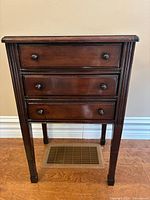 Front view of wooden side table with three drawers
