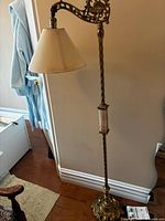 Full view of ornate brass floor lamp with shade