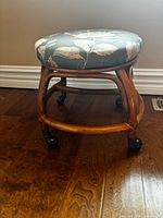 Side view of wooden stool showing legs, stretchers, and casters