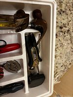Organizer section with two claw hammers, can opener and screwdrivers visible