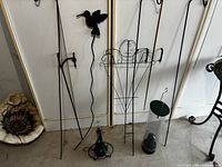 Group of metal shepherd hooks, decorative stakes, trellis, glass feeders and fungus ornament