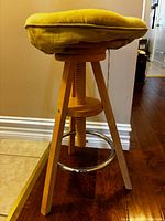 Full view of stool showing legs, cushion, and footrest