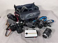 Group shot showing Zenit EM, Olympus OM-1 with Vivitar zoom, Polaroid Z2300, extra Olympus lens, Fotima bag