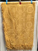 full view of woven mustard throw blanket hanging