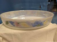 Side view of oval white glass dish showing floral border and overall shape