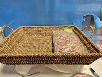 Full view of woven tray basket with bag of raffia inside