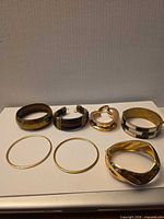 Seven bracelets laid out showing variety of styles and materials