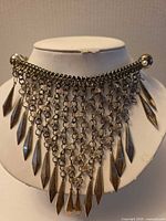 Front view showing chainmail bib and hanging spear dangles
