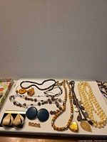Overview of all necklaces and earrings arranged on tray