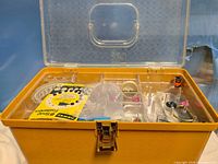 Yellow sewing box with clear lid open showing compartments and contents