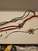 Overview of three bolo ties with distinct slides and cords
