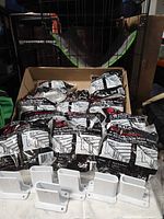 Cardboard box with sealed ClosetMaid wall bracket packs and four loose brackets displayed