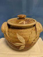 Front view of stoneware bean pot with lid and handles