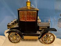 Left side view showing full car decanter form, wheels, amber glass roof and stopper