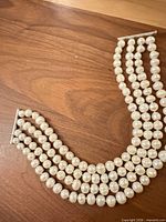 Full view of four-strand pearl choker laid flat