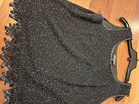 Front view of black chiffon beaded tank showing overall bead pattern and scalloped hem