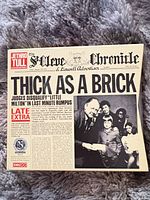 Front of newspaper-style slipcase showing album title and artwork