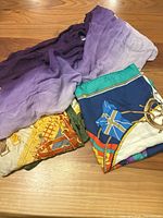 Three folded scarves showing purple chiffon, equestrian design and nautical flag design