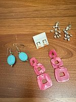 All four pairs of earrings displayed together on wood surface