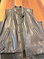 Front view of black leather vest showing overall design and closure