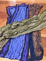 Overview of three scarves: blue striped pleated, green crinkled metallic, blue paisley print