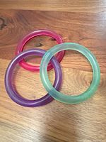Group view of three acrylic bangles in pink, purple, green-clear