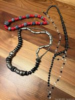 overview of all three necklaces laid out on wood surface