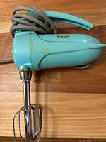 Turquoise Sunbeam hand mixer with beaters attached