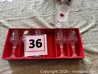 Five glasses in red tray with one additional glass adjacent