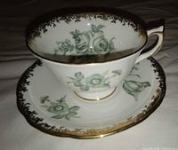 Teacup on saucer showing pattern and gold trim