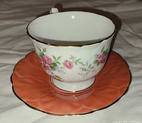 Front view of teacup on coral saucer