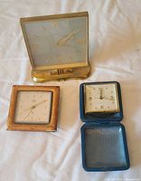 Front view of the three wind-up clocks on cloth background