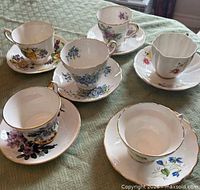 Top view of six assorted teacup and saucer sets on table