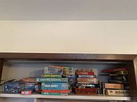 Shelf showing stacked board games and puzzles