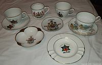 Overview of three teacups, three saucers, one four-lobed dish on table