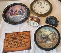 All seven items laid out on cloth: three wall clocks, three desk/alarm clocks, wooden plaque