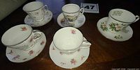 Five Duchess teacup and saucer sets on table showing floral designs