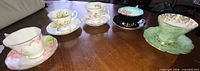 Five assorted Royal Albert teacup and saucer sets displayed on table