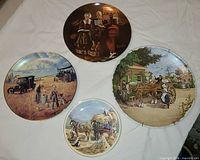 Front view of four decorative plates showing artwork