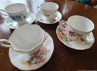 Top view of four floral teacup and saucer sets