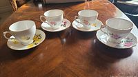 Four Royal Vale teacup and saucer sets on table