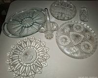All six clear glass service pieces arranged on table