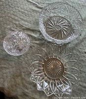 Three glass serving pieces on tablecloth