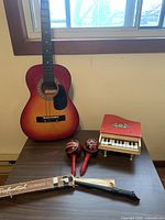 Overall view of guitar, toy piano, maracas, recorder and sleeve