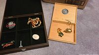 Lot overview showing display case, necklace, pins, miniature car, mouse paperweight in cigar box
