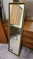 Front view of tall mirror leaning against dresser